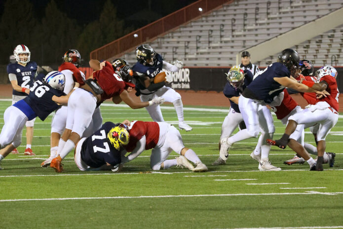 West-All Stars #25 Steven Mack jumps over a defender and runs into the end zone for a 17 yard touchdown. (Mark Haynes, Clarksville Online)