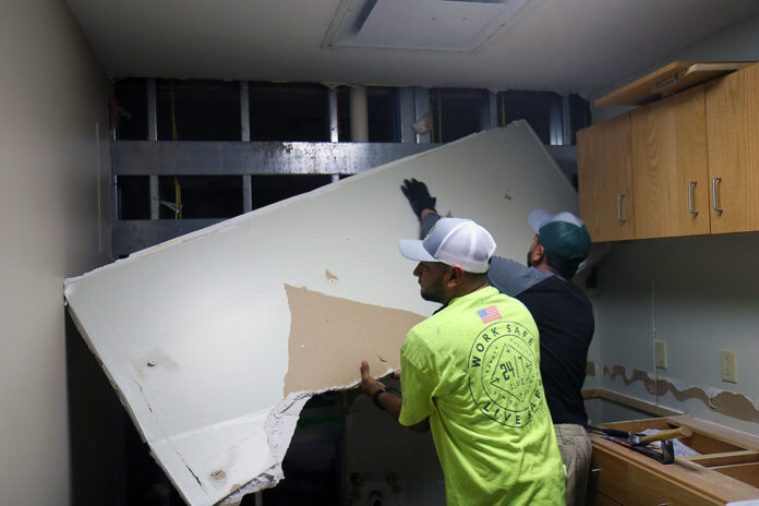 Arnaldo Jiminez, left, and Ronald Zabala right, both production technicians with SkipRock LLC, a local contractor, demolish a section of water-damaged drywall Jan. 3 in barracks Building 7932. The facility sustained significant water damage from a burst fire suppression pipe after a wave of freezing temperatures Dec. 23-27, and the Directorate of Public Works aims to have the building repaired by the time the Soldiers who live there return from a field training exercise in February. (Ethan Steinquest, Fort Campbell Public Affairs Office)