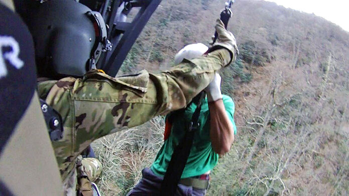 Staff Sgt. Ryan McKnight lowers Staff Sgt. John Sharbel during a recovery mission on the Appalachian Trail, Dec. 31, 2022. Local authorities requested help from the Tennessee Emergency Management Agency and the Tennessee National Guard to rescue two stranded hikers the morning of New Year’s Eve. The two hikers were airlifted to Johnson City Medical Center where they recovered from minor injuries before being released. (Submitted photo)