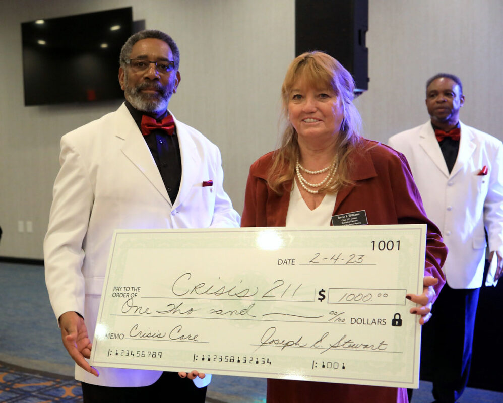 Terrie Williams, Executive Director of Clarksville’s Crisis 211 Center receives a $1,000 check from members of the Joseph E. Stewart Social Club. (Tony Centonze, Clarksville Online)