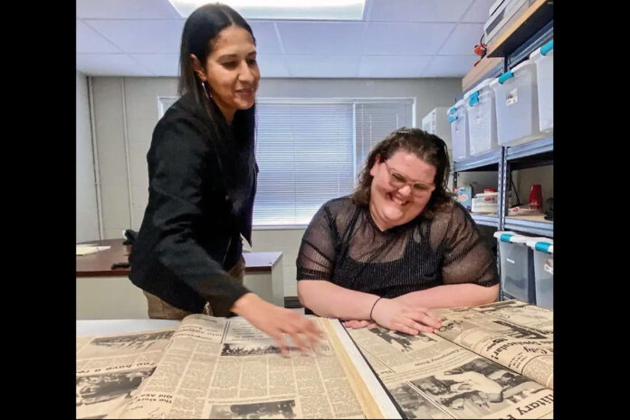 Yvette Smith (left), public affairs specialist, Fort Campbell Public Affairs; and Mari-Alice Jasper, managing editor of the Fort Campbell Courier, look at bound volumes of the Fort Campbell Courier from the past 60 years. Fort Campbell has had a weekly post newspaper since 1950 when the “Courier” was established, according to an article that published in the Fort Campbell Post News January 5th, 1968. (Dawn Grimes, Fort Campbell Public Affairs Office)