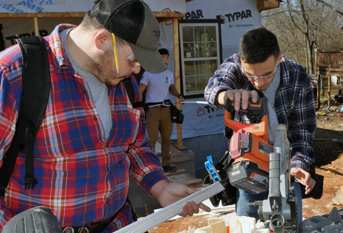 HBI students Davin Donathan (left), Andrew Martinez (right), and Jiwook Cheon (middle background) work on a project at a Habitat for Humanity construction site through The Home Depot Foundation’s Path to Pro program.