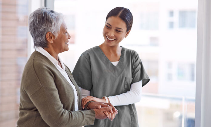 Adobe Stock photo of a medical assistant helping a patient.