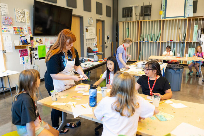 Sarah Spillers, the painting instructor at this year's CSA Summer Arts Camp, helps children develop their art.