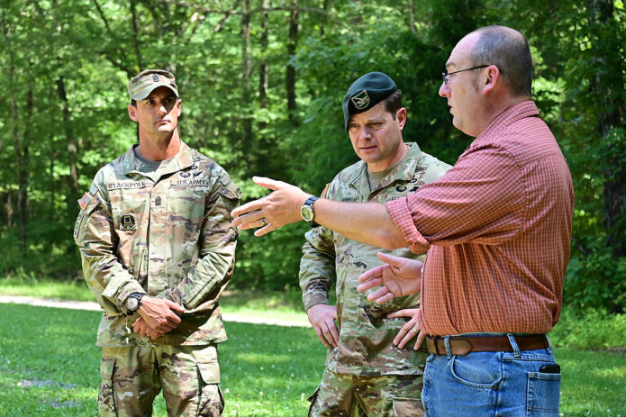 Fort Campbell Garrison Commander Col. Andrew Q. Jordan and Garrison Command Sgt. Maj. Chad Stackpole receive a briefing about Fort Campbell's German POW cemetery from Ron Grayson, the Cultural Resources Management Program manager, July 28. A special marker has recently been placed on the gravesite of over 50 partial Native American remains at the German POW Cemetery, thanks to a unique collaboration between Fort Campbell and the Eastern Band of Cherokee Indians Tribal Historic Preservation Office (EBCI THPO). The marker is engraved with the symbols in the Cherokee Syllabary, which translate to “People from Kituwah.” As part of his final tour as the garrison commander, Jordan, a member of the Cherokee Nation, visited the cemetery. (Kayla Cosby, Fort Campbell Public Affairs Office)