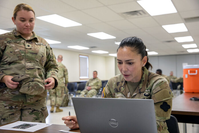 U.S. Army Reserve Capt. Joy Petway, right, senior human resources officer assigned to the 88th Readiness Division, Fort McCoy, Wis., looks at and prepares to record personnel data for U.S. Army Reserve Spc. Nicole Barton, a chemical, biological, radiological and nuclear specialist for the 220th Transportation Company, Keene, N.H; during Operation Enabling Readiness (OER) in Fort McCoy, Wis., Aug. 17, 2023. Held on Aug. 16-25, 2023, the OER pilot program was designed to enhance medical readiness in conjunction with large-scale training exercises such as Combat Support Training Exercise (CSTX). It is a joint synchronization of efforts between 88th RD, Army Reserve Medical Command, Blanchfield Army Community Hospital and Fort McCoy Directorate of Plans, Training, Mobilization and Security - Mobilization Branch. (Staff Sgt. Christopher Hernandez)