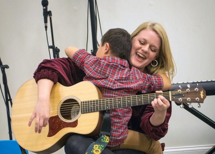 Austin Peay State University assistant professor Lauren Booke and a child participating in a music therapy class. (APSU)