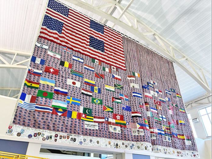 A tribute to the victims of the 2001 attacks on the World Trade Center, the Pentagon, and Flight 93 is currently on display at the Fort Campbell Passenger Processing Center (PPC). The giant flag, measuring 22 by 32 feet, has a powerful significance as it has journeyed through various significant locations. (Kayla Cosby)