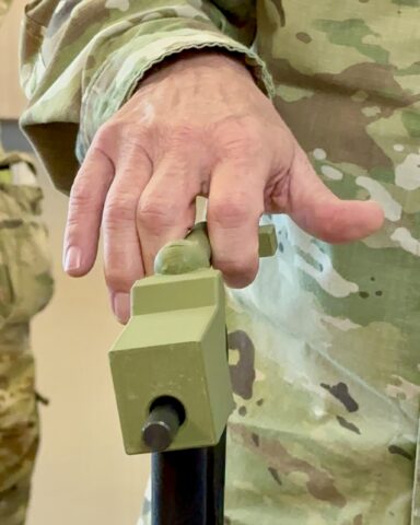 Commanding General, U.S. Army Medical Readiness Command, East, and Director, Defense Health Network East Brig. Gen. Lance Raney tests a simulated M-4 rifle charging handle that attaches to a strength-training machine to simulate real-life tasks for Soldiers recovering from traumatic hand and upper extremity injuries. The attachment, developed by a team from Blanchfield Army Community Hospital’s Occupational Therapy Clinic and Fort Campbell’s EagleWerx Applied Tactical Innovation Center, may gain broader use in other military hospitals and clinics after the senior Defense Health Agency official saw it demonstrated, November 6th.