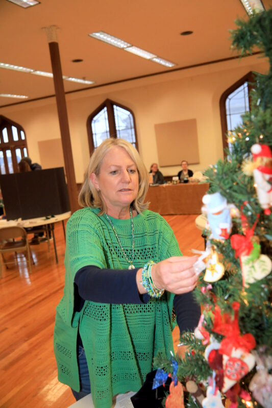 Christie Crawford decorating a tree with hand-painted ornaments