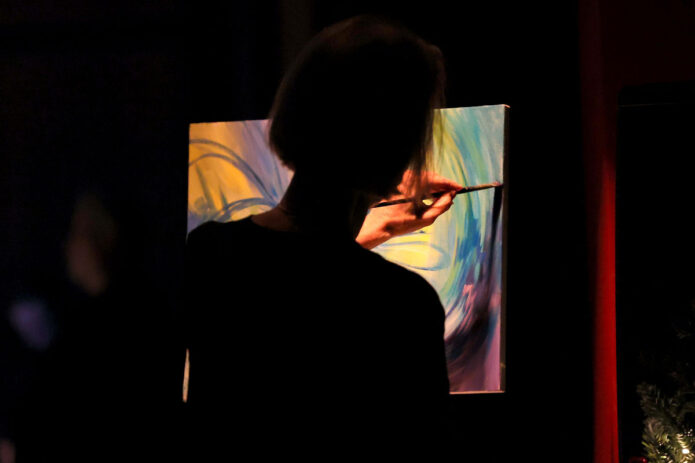 Kitty Harvill painting during the Gateway Chamber Orchestra's "Nutcracker". (Mark Haynes, Clarksville Online)