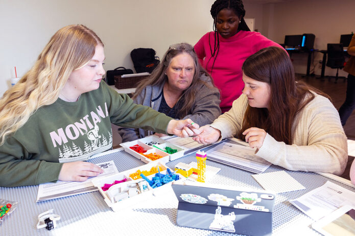 Austin Peay State University students work with a LEGO® Education set, which can be assembled and coded to light up, display different colors and move. These sets are used in the classroom to teach STEM skills in an engaging, fun way. (Sean McCully, APSU)