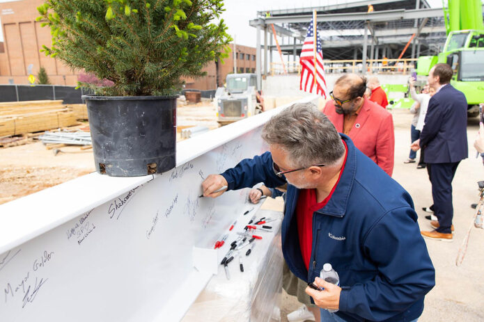 Members of the Austin Peay State University community sign the upcoming Health Professions Building’s final girder during a topping out ceremony. (Madison Casey, APSU)