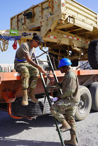 Spc. Lyric Latham and Spc. Douglass Rockwell, assigned to the 267th Military Police Company, verify a DA Form 2855 for a departing unit in the Kuwait Naval Base Sterile Lot on January 9, 2024. (U.S. Army National Guard, Spc. Carlos Hernandez) 