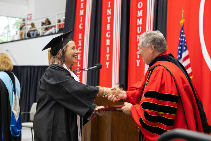 Senior education major Taylor Newton receives a diploma from Austin Peay State University President Michael Licari during a commencement ceremony on August 2nd. (Sean McCully, APSU)