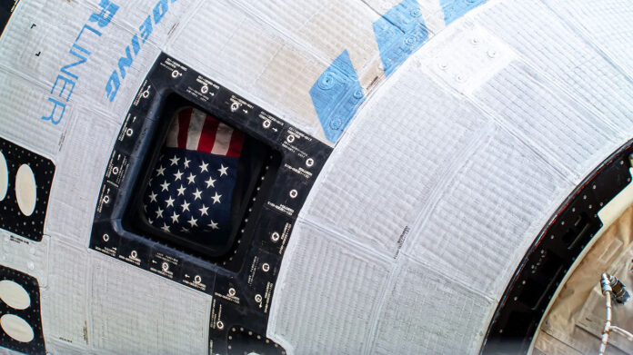 The American flag pictured inside the window of Boeing’s Starliner spacecraft at the International Space Station. (NASA)