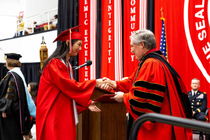 Junior health and human performance major Bo ram Kim shakes hands with Austin Peay State University President Mike Licari during the university’s December 2024 commencement ceremony, where she earned her associate degree. (APSU)