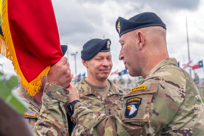Maj. Gen David Gardner, incoming commanding general of the 101st Airborne Division (Air Assault) and Fort Campbell, passes the guidon to Command Sgt. Maj. Charles Walker, command sergeant major of the 101st ABN DIV (AA), during the change of command ceremony, May 30th, 2025, Fort Campbell, Ky. The time honored ceremony marks the transfer of command between one commander to the next. (Staff Sgt. Kaden D. Pitt)