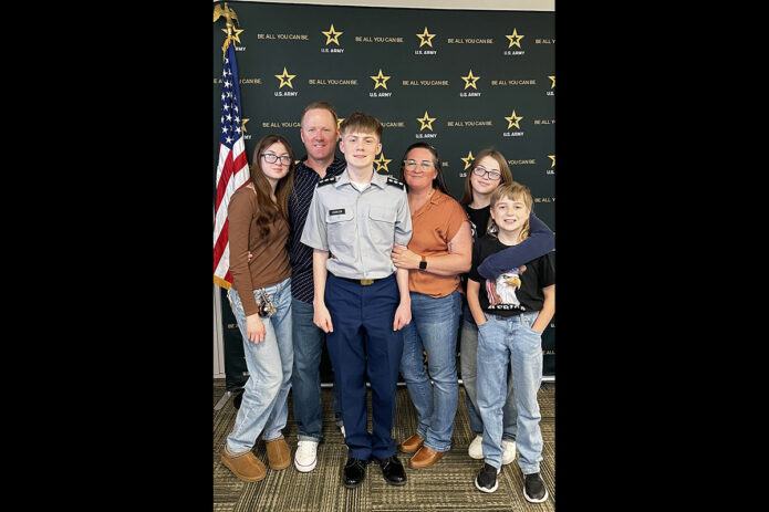 Fort Campbell High School, Ky., graduate Christopher Johnson II, center, poses with his family after enlisting in the Army at an Army recruitment center.