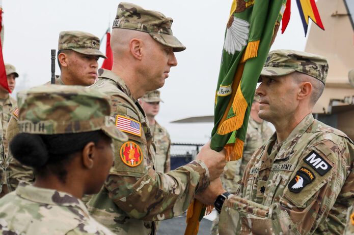 U.S. Army Command Sgt. Maj. David J. Parthemore, assigned to 716th Military Police Battalion under Joint Task Force-Southern Border, passes the unit’s guidon to its outgoing commander, U.S. Army Lt. Col. Phillip Mason, during the unit’s change of command ceremony at San Diego, CA, June 16th, 2025. (U.S. Army photo by Staff Sgt. Christopher Neu) 