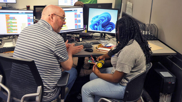 Dr. Mike Wilson, the director of Austin Peay State University’s GIS Center, helps a student program a basic robot during the university’s inaugural Robotics Camp. (Colby Wilson, APSU)