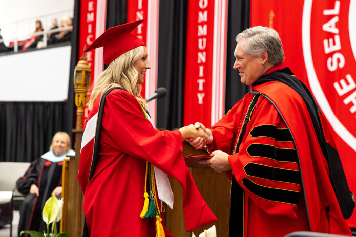 Austin Peay State University alumna Kayla Downey shakes hands with APSU President Mike Licari while receiving her Master of Business Administration. (Sean McCully, APSU)