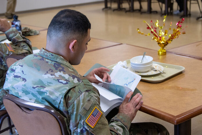 A U.S. Army Soldier assigned to the 101st Airborne Division (Air Assault) looks through his motorcycle safety packet at Son Cafe on Fort Campbell, KY, July 1st, 2025. The Motorcycle Safety Mentorship Lunch was held by the Installation Safety Office as an opportunity to educate experienced riders and NCOs on how to mentor and encourage safe practices among the riders in their units. (U.S. Army photo by Pfc. Jayden Woods) 