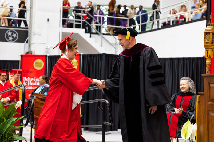 Maggie Lehtola shakes hands with Dr. William “Buzz” Hoon, dean of APSU’s College of Arts and Letters, during her May 2025 graduation. (Sean McCully, APSU)