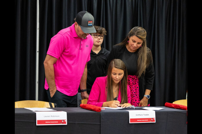 EmMarie Tisdale, a teacher resident with Robertson County Schools, signs her teaching contract surrounded by her family, July 21st, at Austin Peay State University. (Sean McCully, APSU)