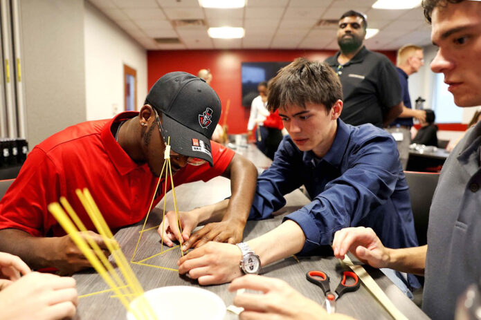 Joshua Martin, left, teams up with Issac Billeter, center, and Andrew Schramkowski on an engineering puzzle during the program. (APSU)