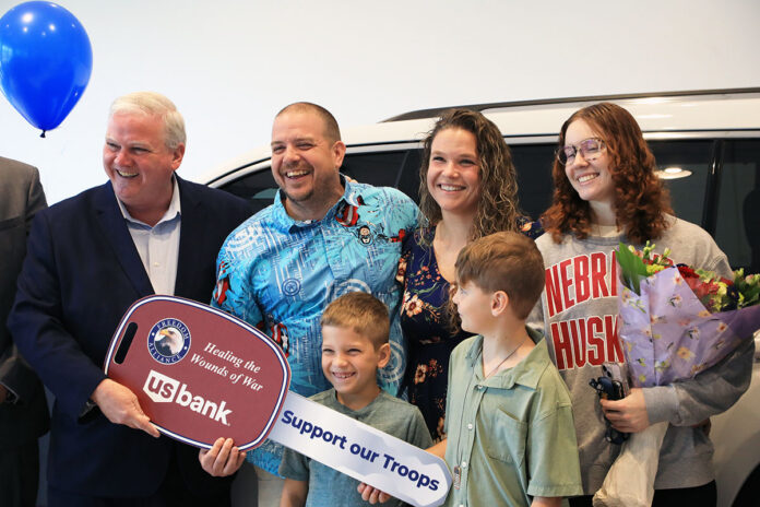 Freedom Alliance President Tom Kilgannon presents Sgt. John Moore and his family with the key to their new vehicle. (Tony Centonze, Clarksville Living Magazine)