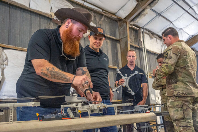 A civilian working with the EagleWERX Applied Tactical Innovation Center repairs a small-unmanned aircraft system on Oct. 10, 2024, at Fort Campbell, Ky. The drones are set to be tested during Operation Lethal Eagle in the spring of 2025. (Staff Sgt. Kaden D. Pitt, 101st Airborne Division)