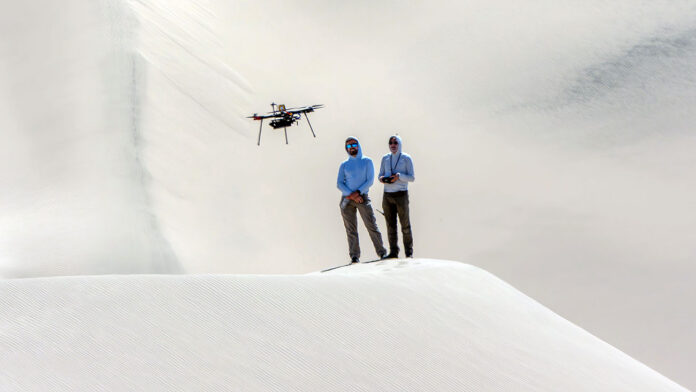Researchers from NASA’s Jet Propulsion Laboratory in Southern California monitor a research drone in the Dumont Dunes area of the Mojave Desert in September as part of a test campaign to develop navigation software to guide future rotorcraft on Mars. (NASA/JPL-Caltech)