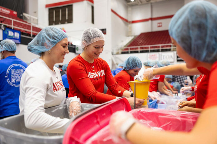 Austin Peay State University women’s soccer team student-athletes measure and scoop rice for a jambalaya recipe. Each bag feeds approximately four to six people and can be prepared using only boiling water. (Sean McCully, APSU)