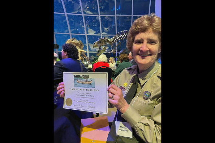 Interpretive Ranger Christa Davidson of Paris Landing State Park shows the Award of Excellence from the Tennessee Association of Museums for a tactile trail at the park.