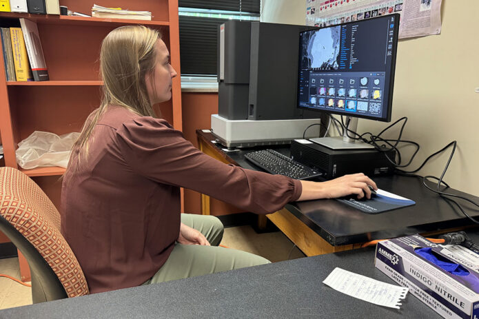 Dr. Amanda Stadermann, an assistant professor in the Department of Earth and Environmental Sciences, demonstrates the capabilities of the scanning electron microscope. (Colby Wilson, APSU)