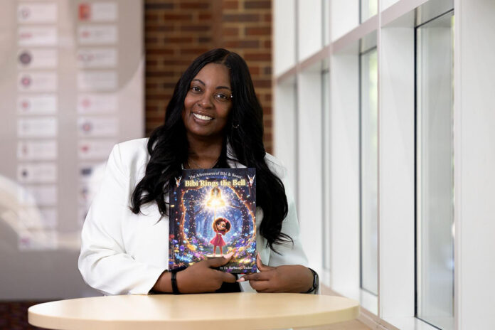 Dr. Barbara Tucker, Austin Peay State University’s director of technical services, with one of the books from ‘The Adventures of Bibi and Beaux,’ a series based on her experience with brain cancer that was recently published in hardcover. (Sean McCully, APSU)
