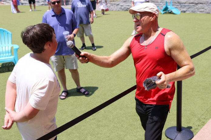 A teenager proudly celebrates after correctly identifying John Hancock as the first person to sign the Declaration of Independence, earning an America 250 patriotic ball cap during Joe Padula's Patriotic Trivia at Downtown Commons. (Mark Haynes, Clarksville Online)