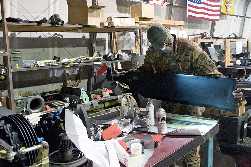 Spc. Sergio Wiley, D Company, 1st Battalion, 101st Combat Aviation Brigade, AH-64 Apache helicopter mechanic uses his headlamp to inspect a tail rotor blade for dents, cracks and uneven finish after applying black paint at Forward Operating Base Salerno, Afghanistan, Jan. 24, 2013. (U.S. Army photo by Sgt. Duncan Brennan, 101st CAB public affairs) Spc. Sergio Wiley, D Company, 1st Battalion, 101st Combat Aviation Brigade, AH-64 Apache helicopter mechanic uses his headlamp to inspect a tail rotor blade for dents, cracks and uneven finish after applying black paint at Forward Operating Base Salerno, Afghanistan, Jan. 24, 2013. (U.S. Army photo by Sgt. Duncan Brennan, 101st CAB public affairs)