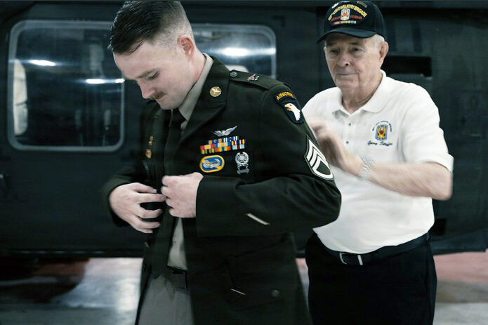 U.S. Army Col. William Zielinski, a military intelligence officer, reinstates and promotes Austin Waring from specialist to staff sergeant during a ceremony at Sabre Airfield, Fort Campbell, Kentucky, August 7th, 2026. Zielinski and Waring connected through the Department of War COVID-19 Reinstatement and Reconciliation Task Force after both previously left the Army following their refusal of the COVID-19 vaccine. (Capt. Jennifer French, 101st Airborne Division)