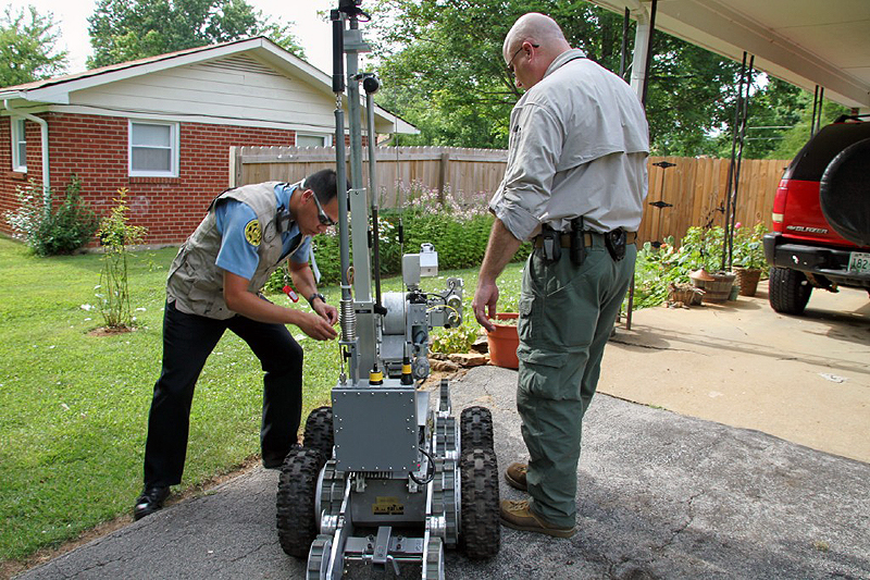 Bomb Squad techs with the robot after the discharge of the water cannon. Bomb Squad techs with the robot after the discharge of the water cannon.