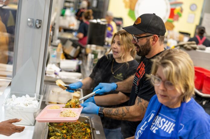 Volunteers serving hot meals to guests at Loaves & Fishes